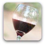 A glass of red wine raised in a toast