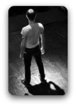 Young man standing in a spotlight on a stage Young man standing in a spotlight on a stage